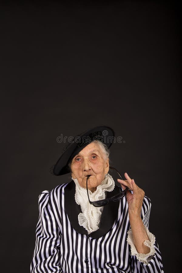 Παλαιό grandma σε ένα άσπρος-μαύρο ριγωτό σακάκι στοκ φωτογραφία